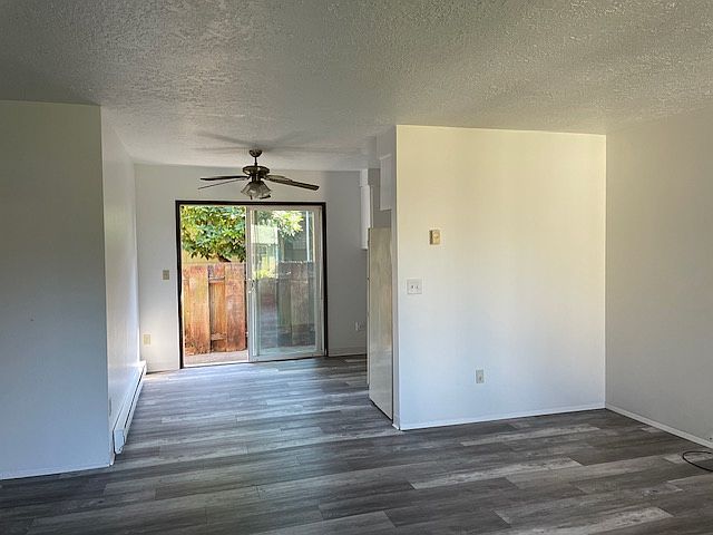 Picture from standing in the livingroom facing dining area/back sliding door/back fenced in yard, kitchen to the right, bedrooms and bathroom to the left