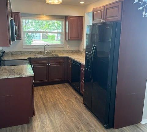 Kitchen with granite counter tops and dishwasher, microwave, stove and refrigerator.
