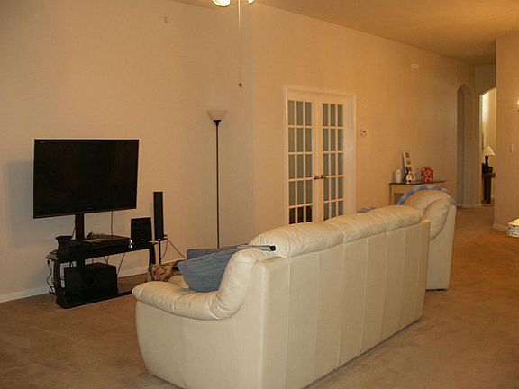 ANOTHER VIEW OF DEN SHOWING THE FRENCH DOORS INTO STUDY