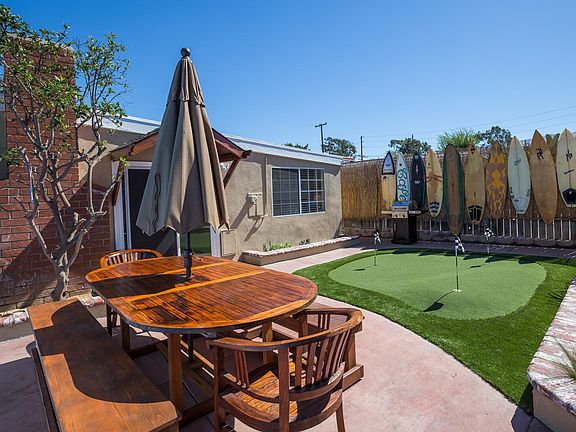 Private Backyard with Putting Green and 8 foot Teak Table and Chairs. Barbecue grill