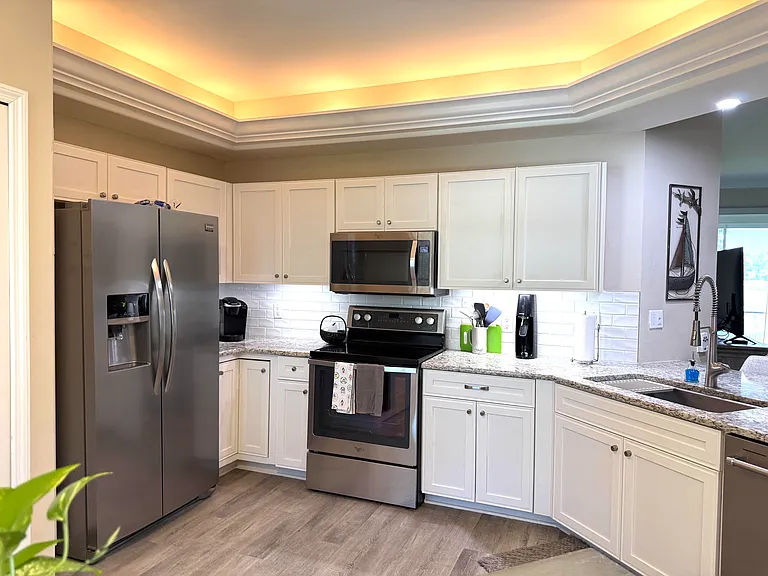 Remodeled open kitchen, granite, cabinets, stainless, hard surface flooring throughout condo.