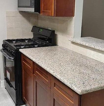 Another view of the kitchen with a new stove and microwave.