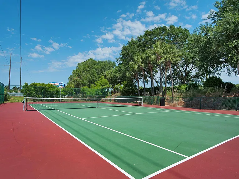 The tennis court is at the back of the house