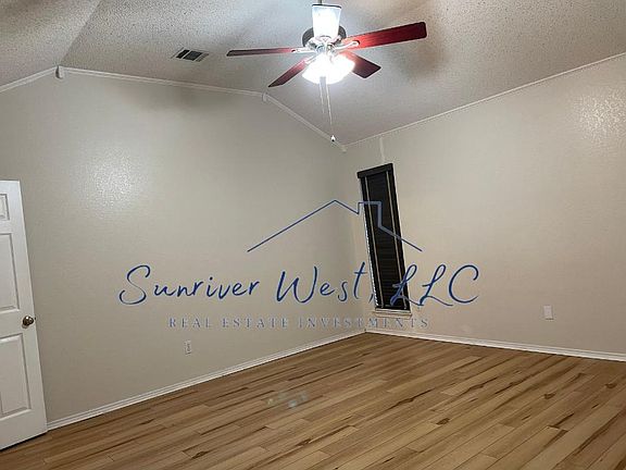 Large primary bedroom with vaulted ceilings and attached bathroom