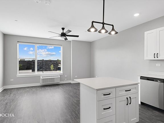 Open concept apartment with stainless steel appliances, granite counters, and soft close white cabinets.