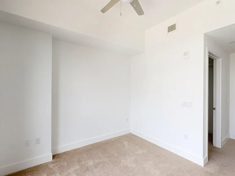 Spacious apartment Bedroom with carpet flooring.