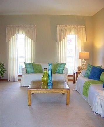 View of living room with large windows providing lots of natural sunlight.