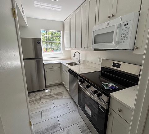 Kitchen with all new cabinets, appliances and flooring. Included: refrigerator, dishwasher, oven, microwave.
