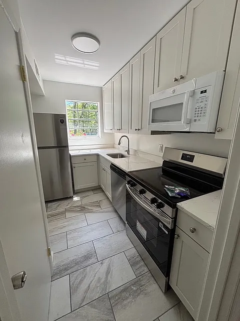Kitchen with all new cabinets, appliances and flooring. Included: refrigerator, dishwasher, oven, microwave. - 235 Keowee Trl #4