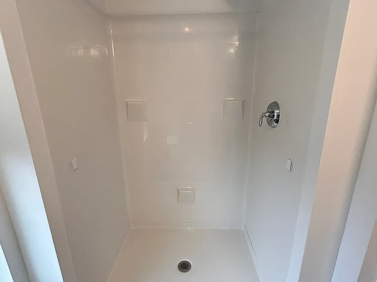 Deep stand up shower with natural light in the bath room.