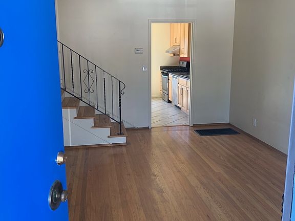 Front door opens to Living room with hardwood floors and kitchen in next room