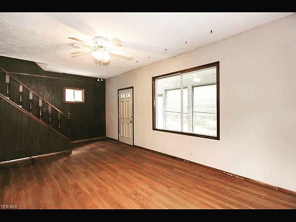 Living room picture window opens to the sunroom/screened porch.