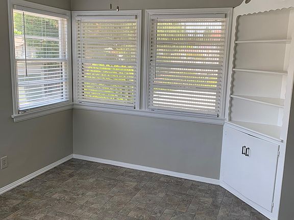 Sunny separate dining room with six windows and built in cabinet.