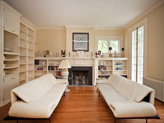 Front room/parlor has extensive built-ins and floor-to-ceiling windows that open out to the front porch.