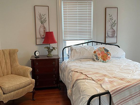 Bedroom 1 upstairs with a full bed, chair, end table, dresser, desk and chair. Double closet