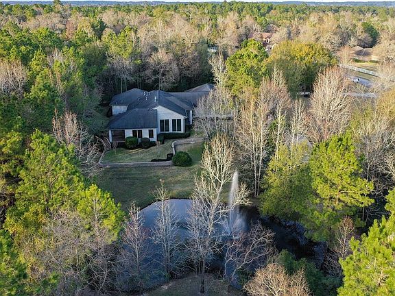 TOTAL PRIVACY ON BEAUTIFUL WOODED LOT - Positioned on 3 acres centered in Crown Oaks, Montgomery, Texas, this wonderfully designed home was custom built for the seller. Large picture windows surround the home to view the extensively landscaped design