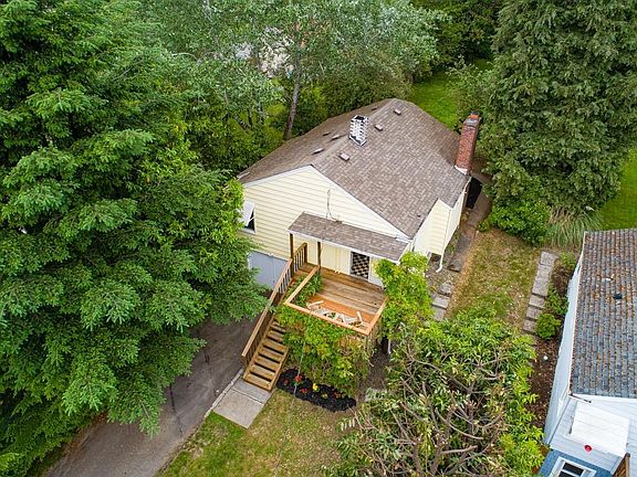 This aerial image provides a back and side yard perspective. The cottage partially seen to the right currently operates as an AirBnB and is booked through the summer with peak season rates of $249/night.
