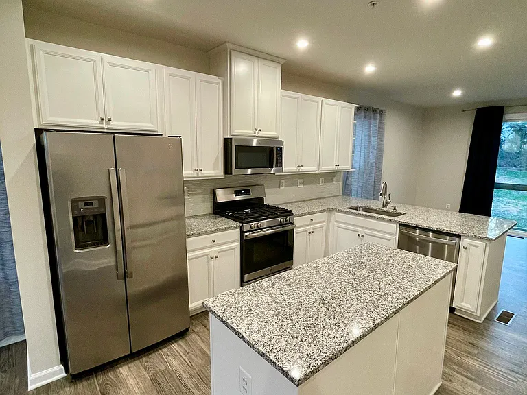Spacious kitchen with large island, granite counters, and gas cooking