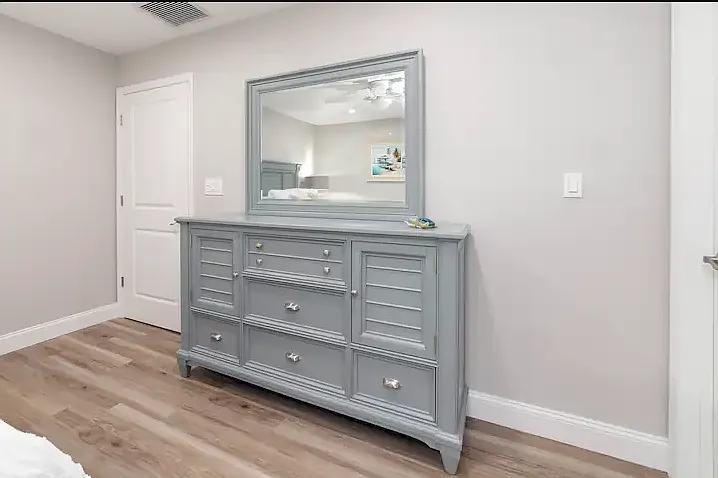 Primary bedroom has a queen bed, dresser, closet, smart TV, and ensuite bath.