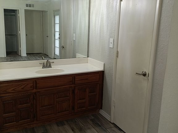 Sink and storage closet, view of walk-in closet in mirror.
