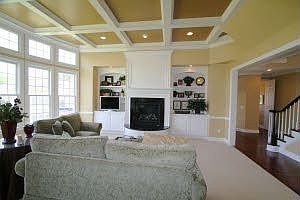 Custom granite on raised hearth - coffered ceiling - bowed wall of windows