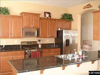 Kitchen w/slab granite counters; stainless appliances; maple cabinets