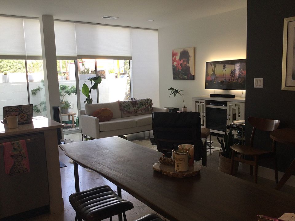 Open kitchen has a counter height table with 3 leather bar stools.