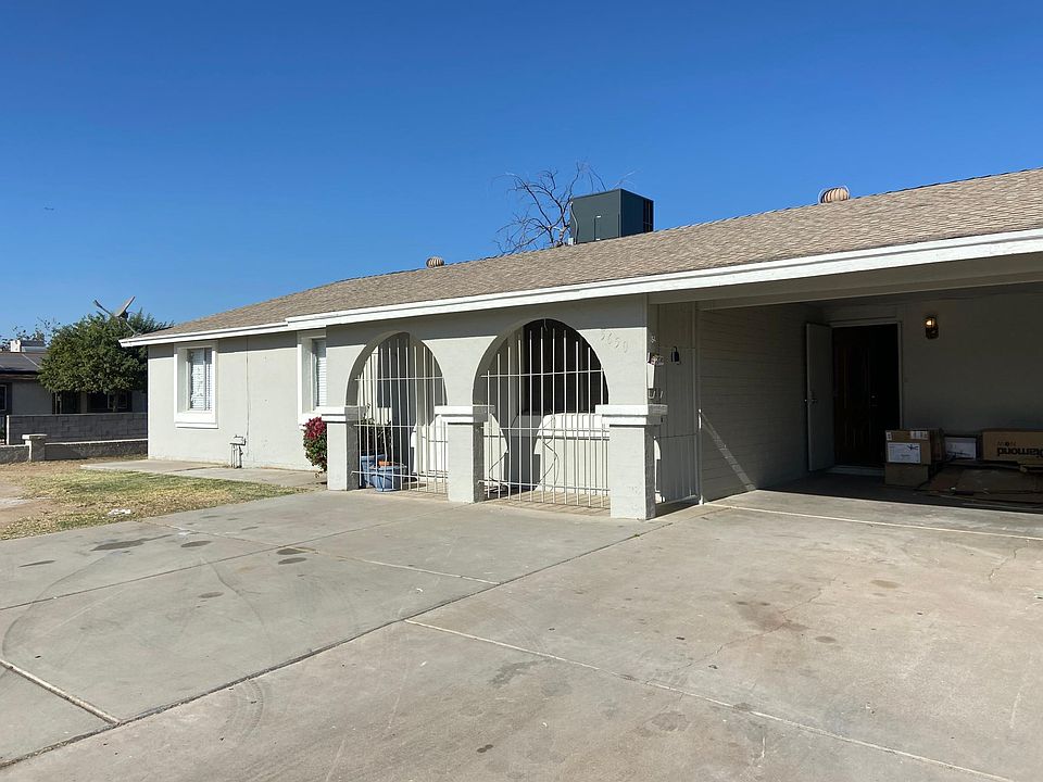 Front of home. Large driveway and covered carport