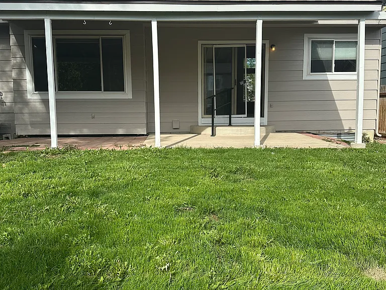 Back of home shows covered patio area. Fully fenced backyard.