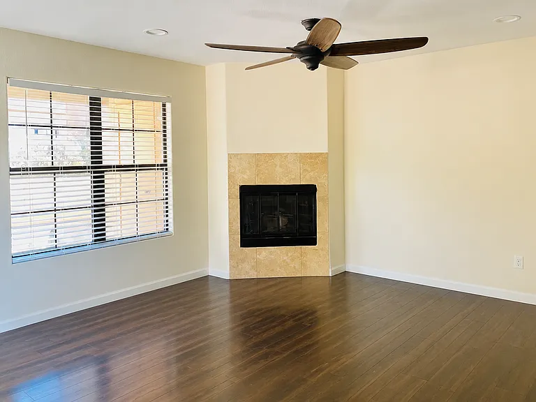 Open, spacious living room with ceiling fan and spotlights