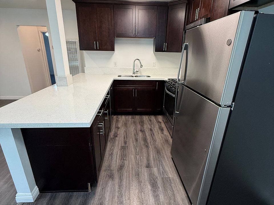 Gourmet Kitchen with Quartz countertops and stainless steel appliances, including a brand new state-of-the-art refrigerator.