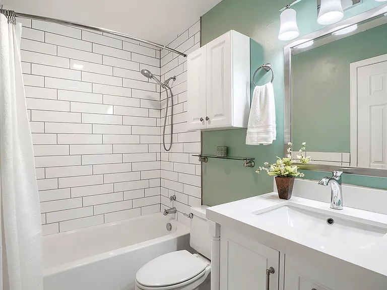 Primary Bathroom _ A well-appointed bath featuring a modern vanity, bathtub, detachable showerhead, and additional storage.