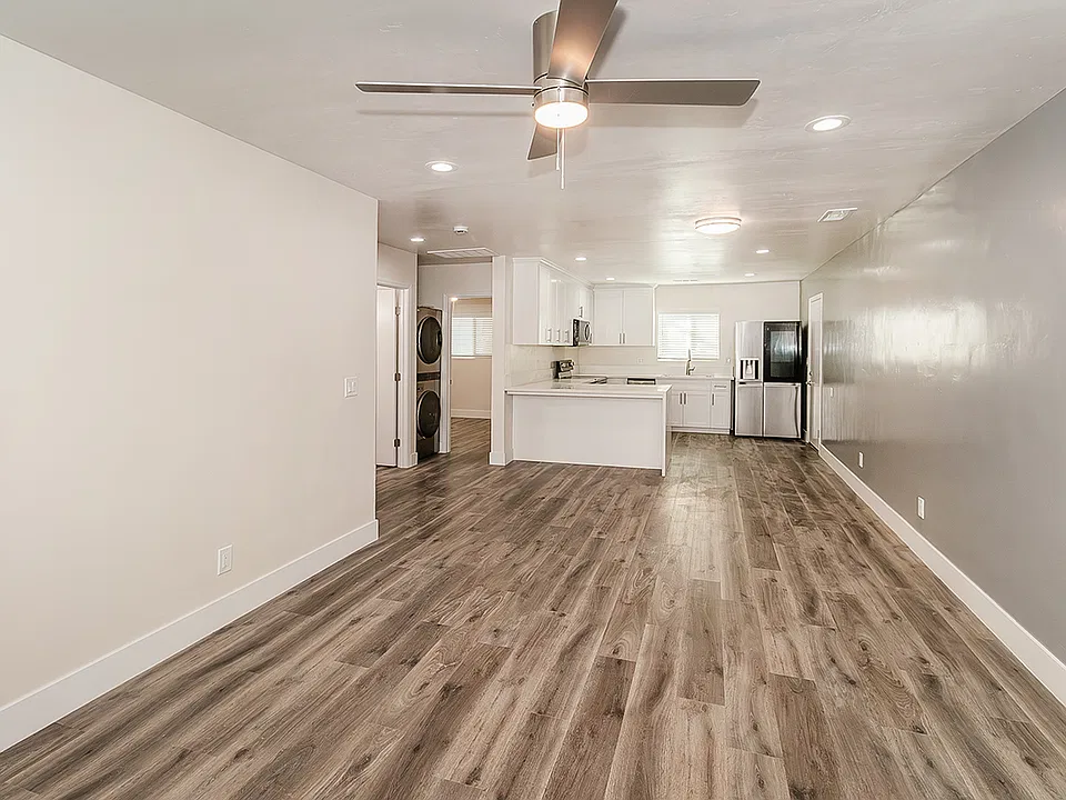 Open Concept Living/Family Room with LVP Flooring, Fan, LED lighting and custom wall finishes.