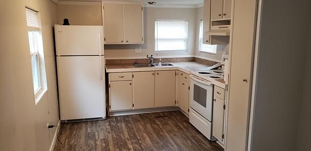 The kitchen has a nice tile countertop, clean fridge and stove, plenty of cabinets, nice pantry area, and 2 windows looking out toward the drive.