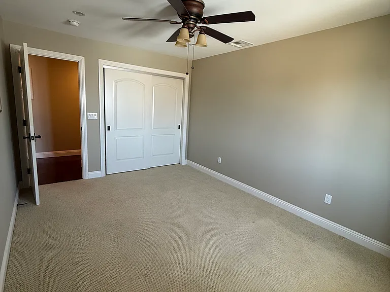 Bedroom 1 with ceiling fan and carpet floor