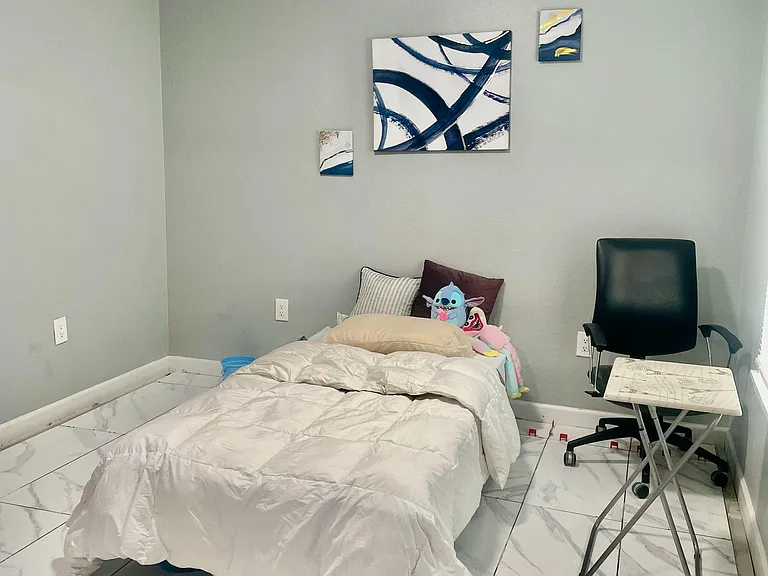 Private bedroom with tiled floors, overhead lighting, and space for a bed plus a desk setup for studying or remote work.