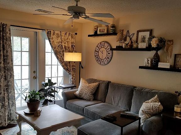 Living/family room has french door out to covered balcony with storage closet. Decorative shelving on the wall remains with the unit.