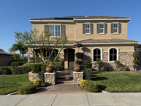 Beautifully landscaped front yard with a private walking trail alongside.