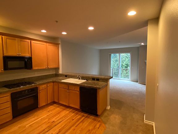 Hardwood floors in kitchen and bar opening up into living room for entertaining.