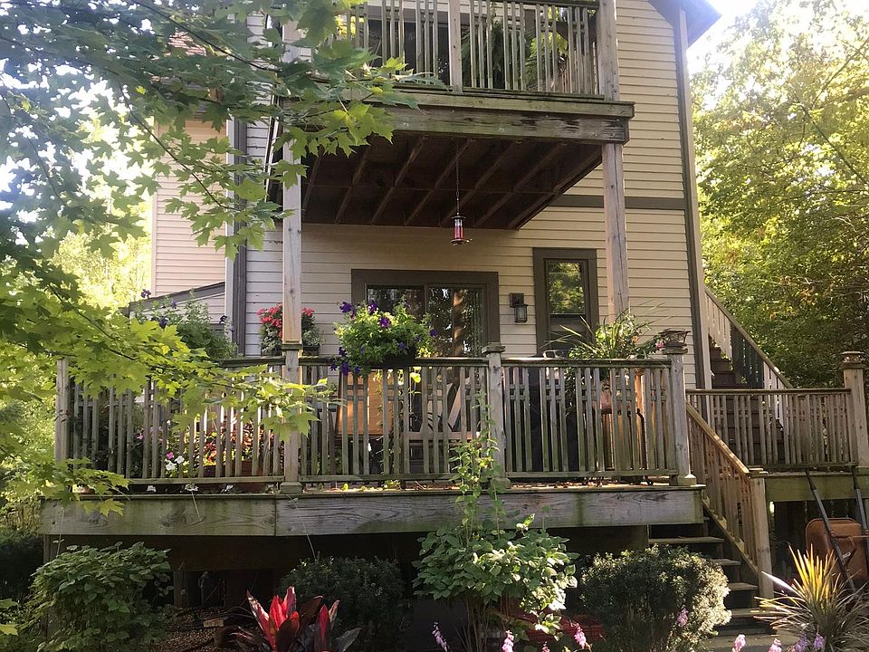 Back facade of building with private decks for each unit and lush back yard.