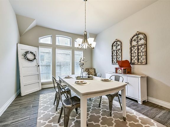 Formal Study through French Doors Features Arched Window and Accent Wall.
