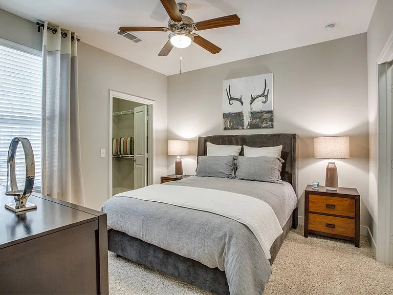 Large bedroom with carpet flooring, natural light, ceiling fan