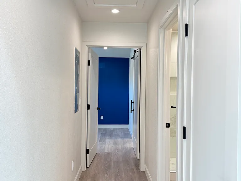Hallway with full bathroom and closet laundry room.