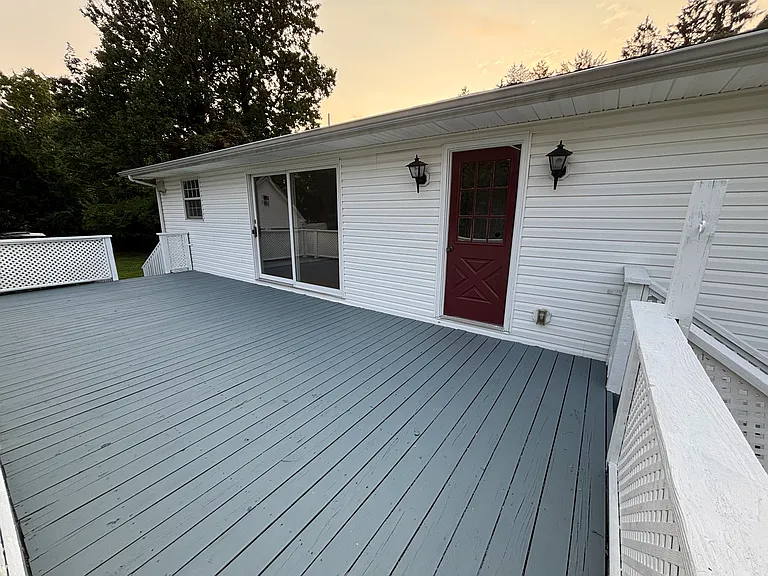 Expansive rear deck offering the perfect space for outdoor dining, entertaining, or simply relaxing while enjoying the privacy of the nearly one-acre lot.