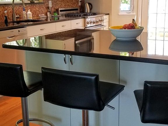 Modern kitchen, gas stove, countertop seating.
