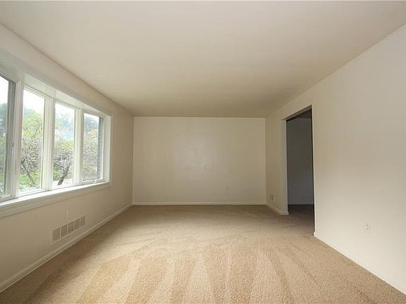 The spacious living room is freshly painted and has new neutral colored carpet. The large bow window showers the room in natural