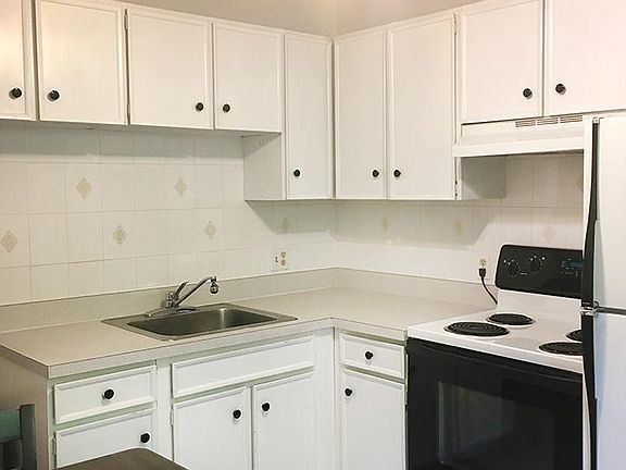 Eat-in kitchen with white cabinets, tile floors and appliances included.