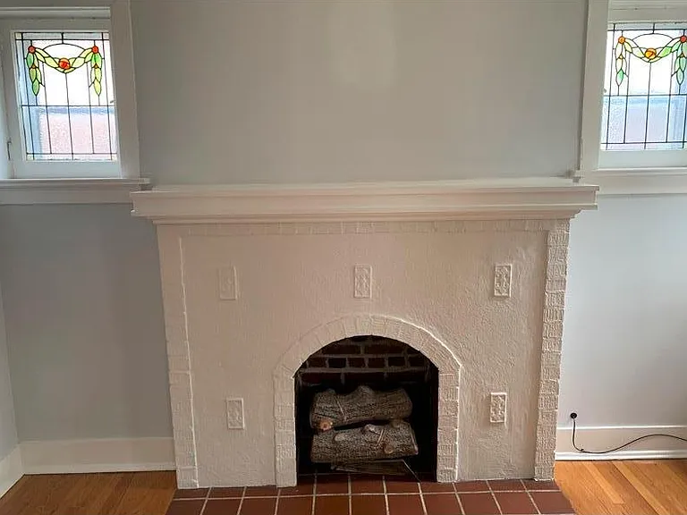 Stainless windows and charming fireplace in living room.