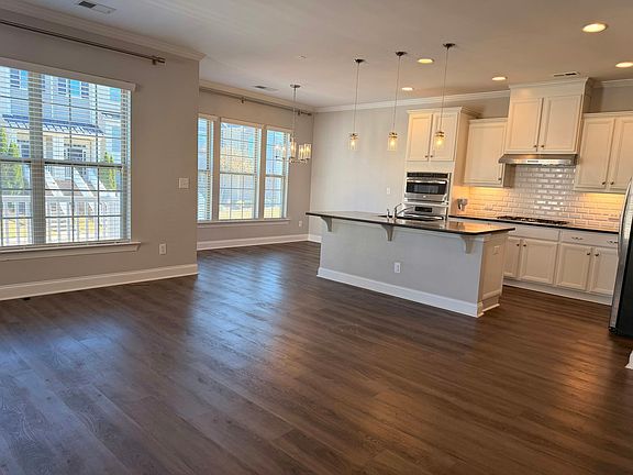 Bright, open-concept kitchen, dining, and living area with abundant natural light.