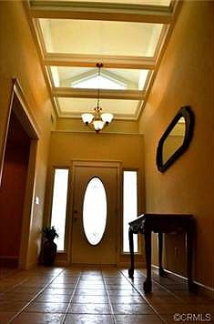 The entryway has a soaring ceiling with natural light flowing in